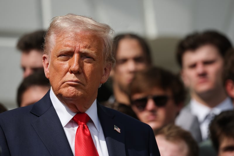 U.S. President Donald Trump listens as Ohio State Head Coach Ryan Day speaks as he welcomes the 2025 College Football National Champions from Ohio State University to the White House during a ceremony on the south lawn on April 14, 2025 in Washington, DC.