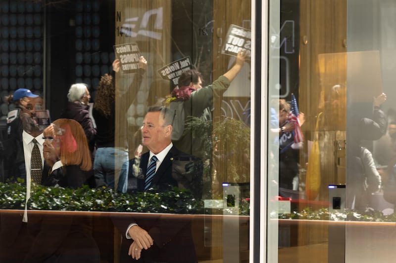 Security guards watch as people protest outside of the offices of Paul Weiss on March 25, 2025 in New York City.
