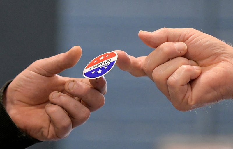 A voter receives a sticker after casting his ballot on Election Day, November 5, 2024, in Gray, Maine.