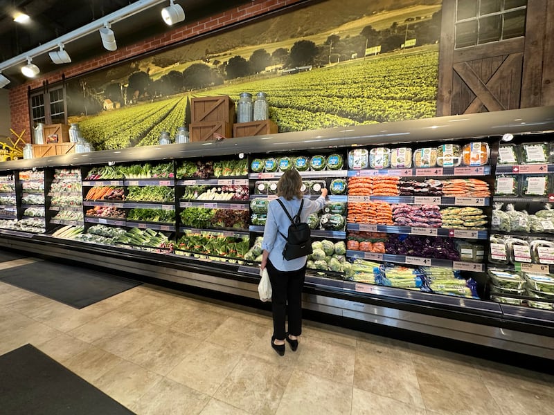 TORONTO, ON - May 12 - A shopper reaches for a container of lettuce at a Farm Boy grocery store in the YongeEglinton area in Toronto. Lance McMillan/Toronto StarMay-12-2023 (Lance McMillan/Toronto Star via Getty Images)