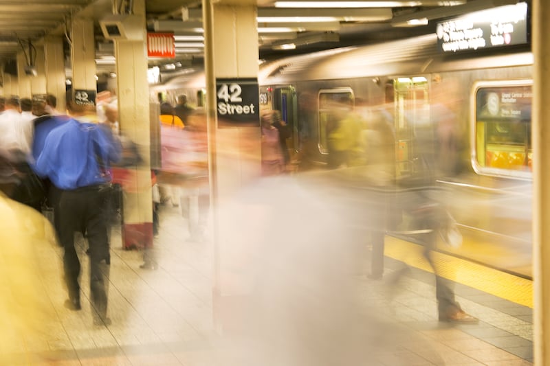 Commuters board and exit a New York City subway train at Times Square station.