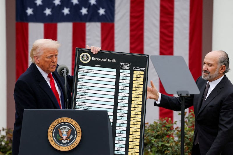 U.S. President Donald Trump holds a chart next to U.S. Secretary of Commerce Howard Lutnick as Trump delivers remarks on tariffs in the Rose Garden at the White House in Washington, D.C., U.S., April 2, 2025. REUTERS/Carlos Barria/File Photo
